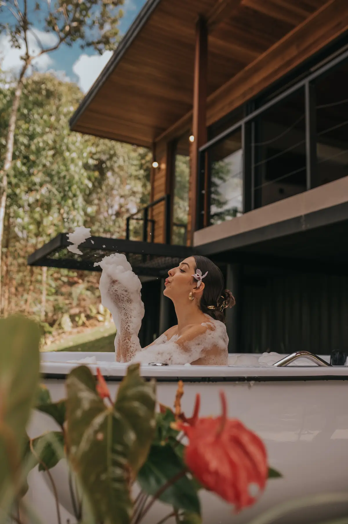 Hóspede na banheira de hidromassagem da Cabana Floresta, entre as flores