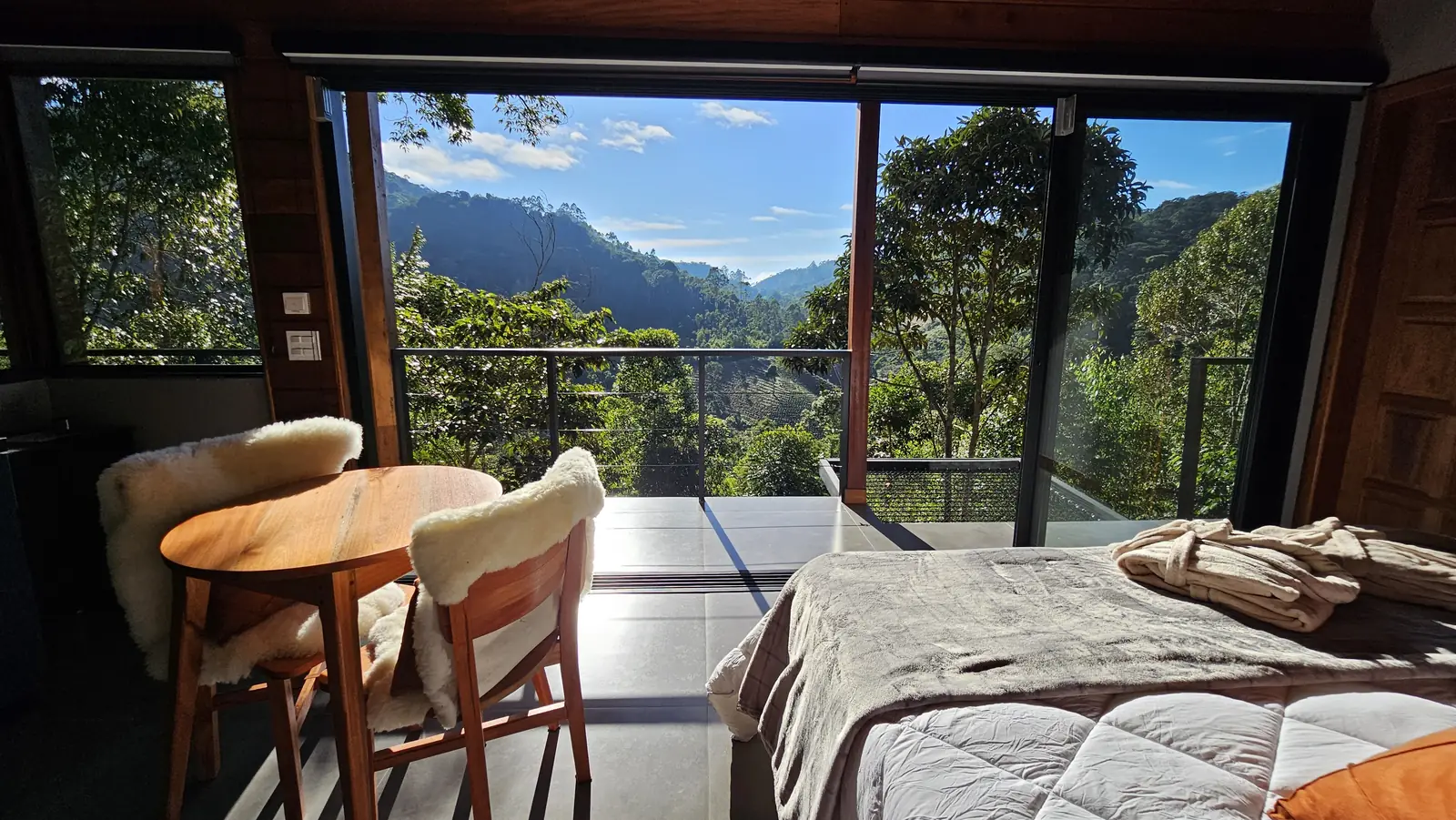 Quarto da Cabana Floresta, com janelas de vidro voltadas para a serra